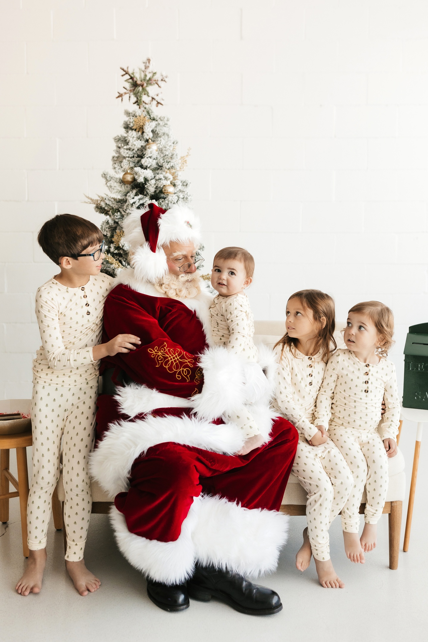 Santa Albert sharing a joyful Christmas moment with four children in matching holiday pajamas