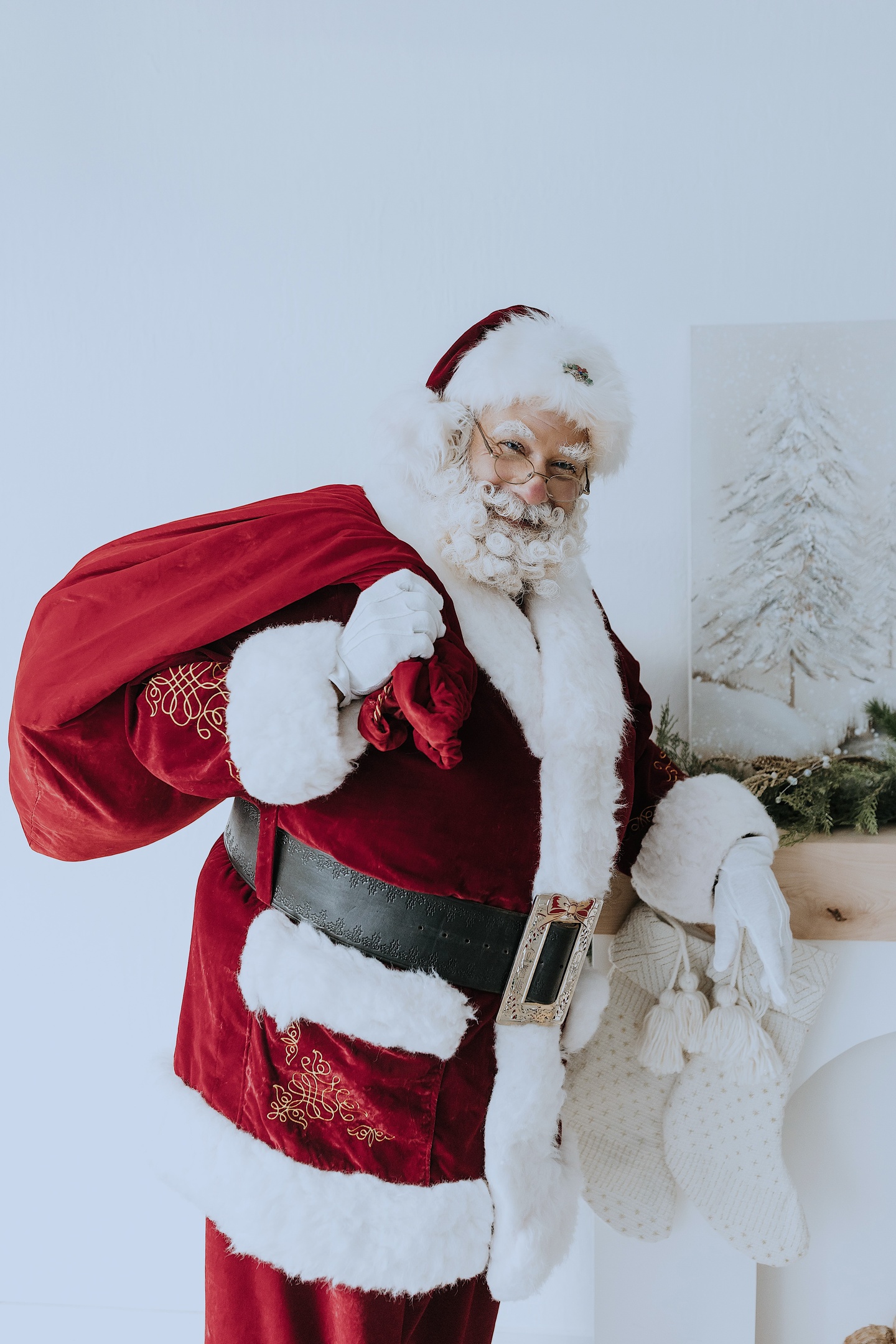 Santa Albert carrying a red toy sack during a professional Christmas portrait session