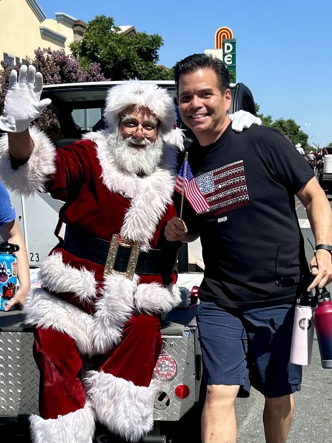 Santa Albert waving beside a community member at the Brentwood Fourth of July Parade in 2024